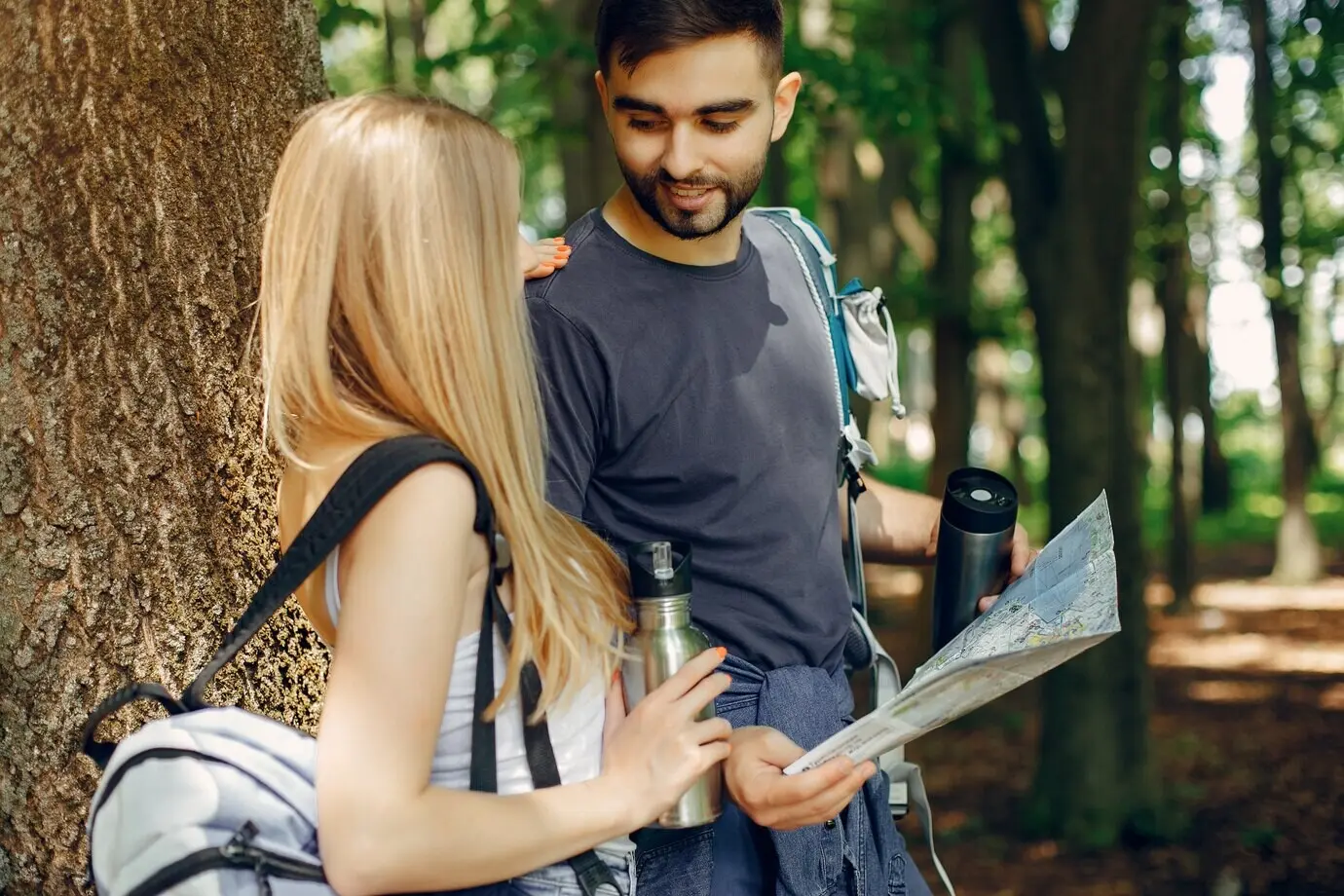 A cute couple is resting in a summer forest.