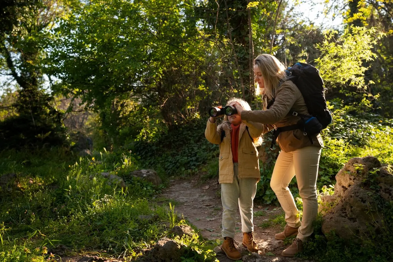 A full shot of a woman and a girl exploring nature.